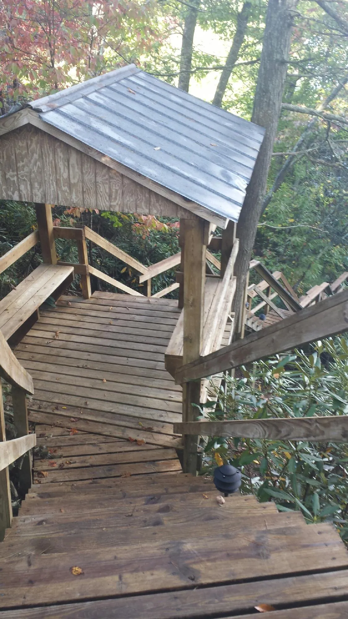 Metal roofed shelter over wooden steps on a wooded walkway — Skylight Repair & Installation work by our crew in Weiser
