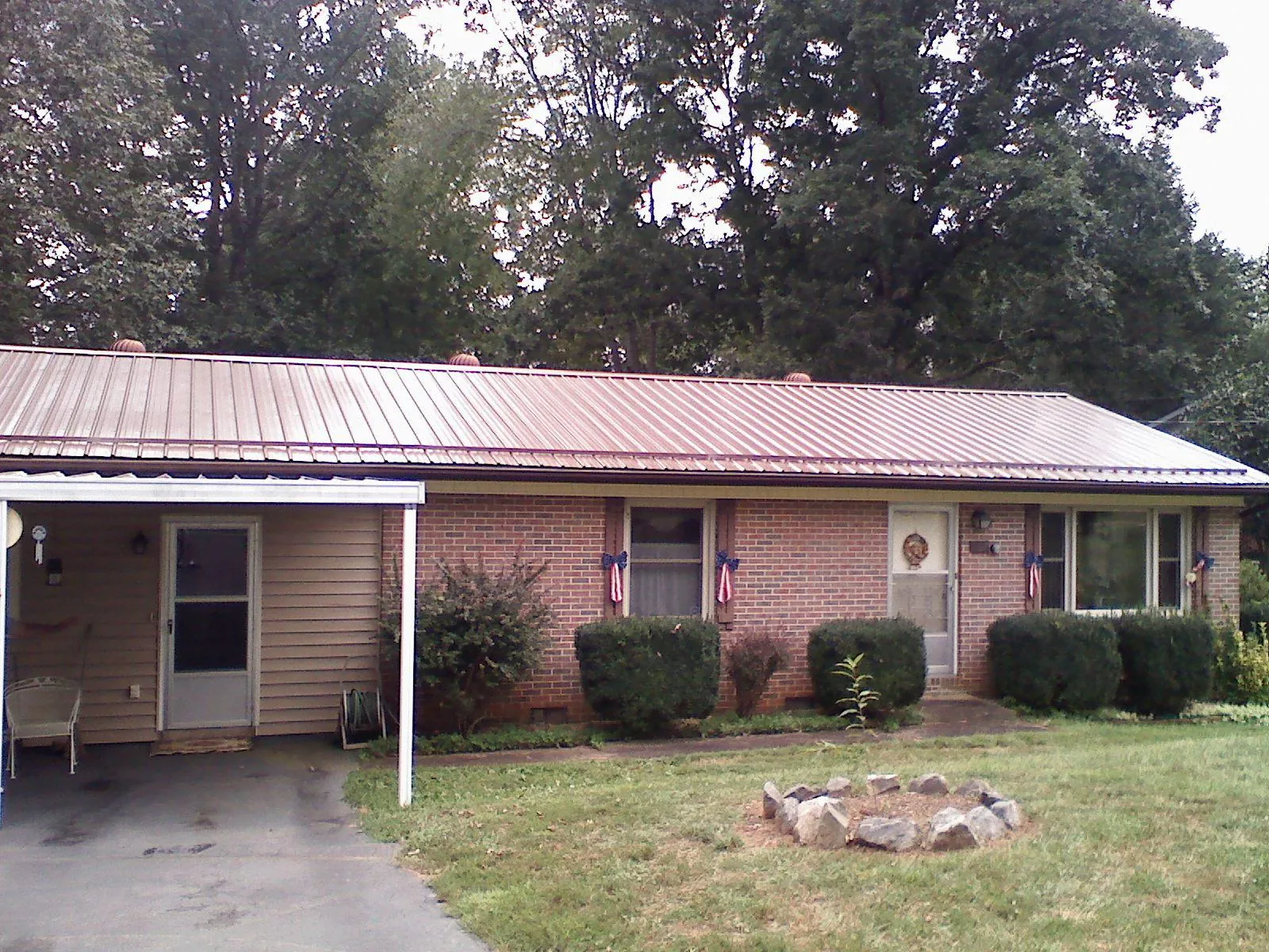 Bronze metal roof and carport on a brick ranch home — Roof Repair work by our crew in Weiser